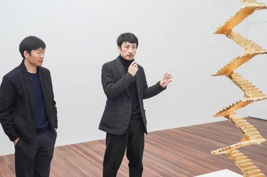 策展人戴卓群（左）与艺术家蔡磊在现场导览  